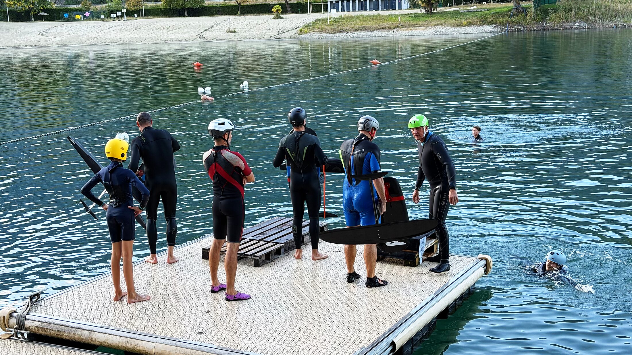 Riders en combinaison sur le ponton, foils à la main